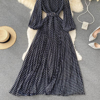 Flowy polka dot pleated dress with matching color belt